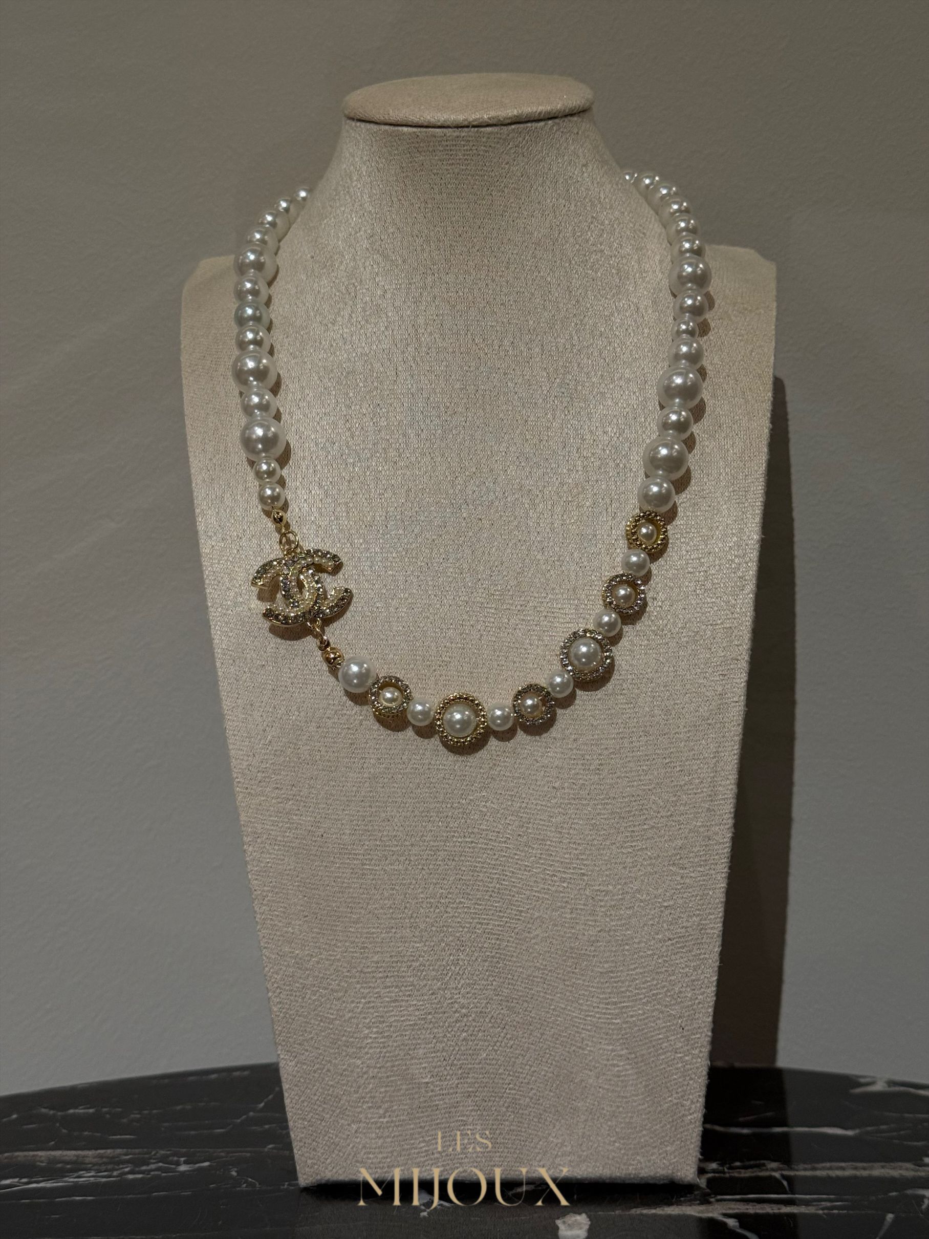 Parelketting met gouden Chanel-logo en accenten op een paspop.