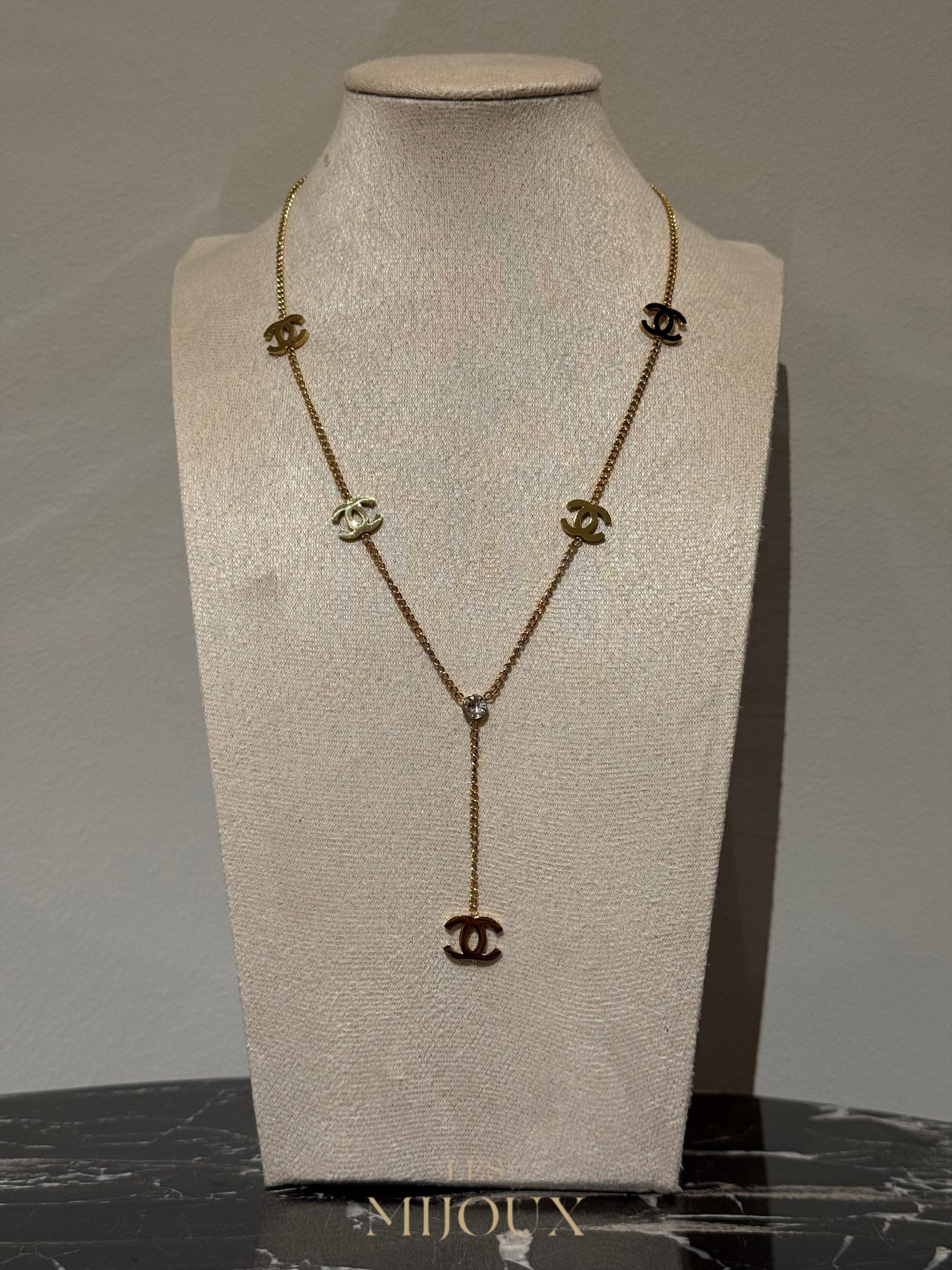Gouden Chanel-halsketting op een paspop, met meerdere in elkaar grijpende