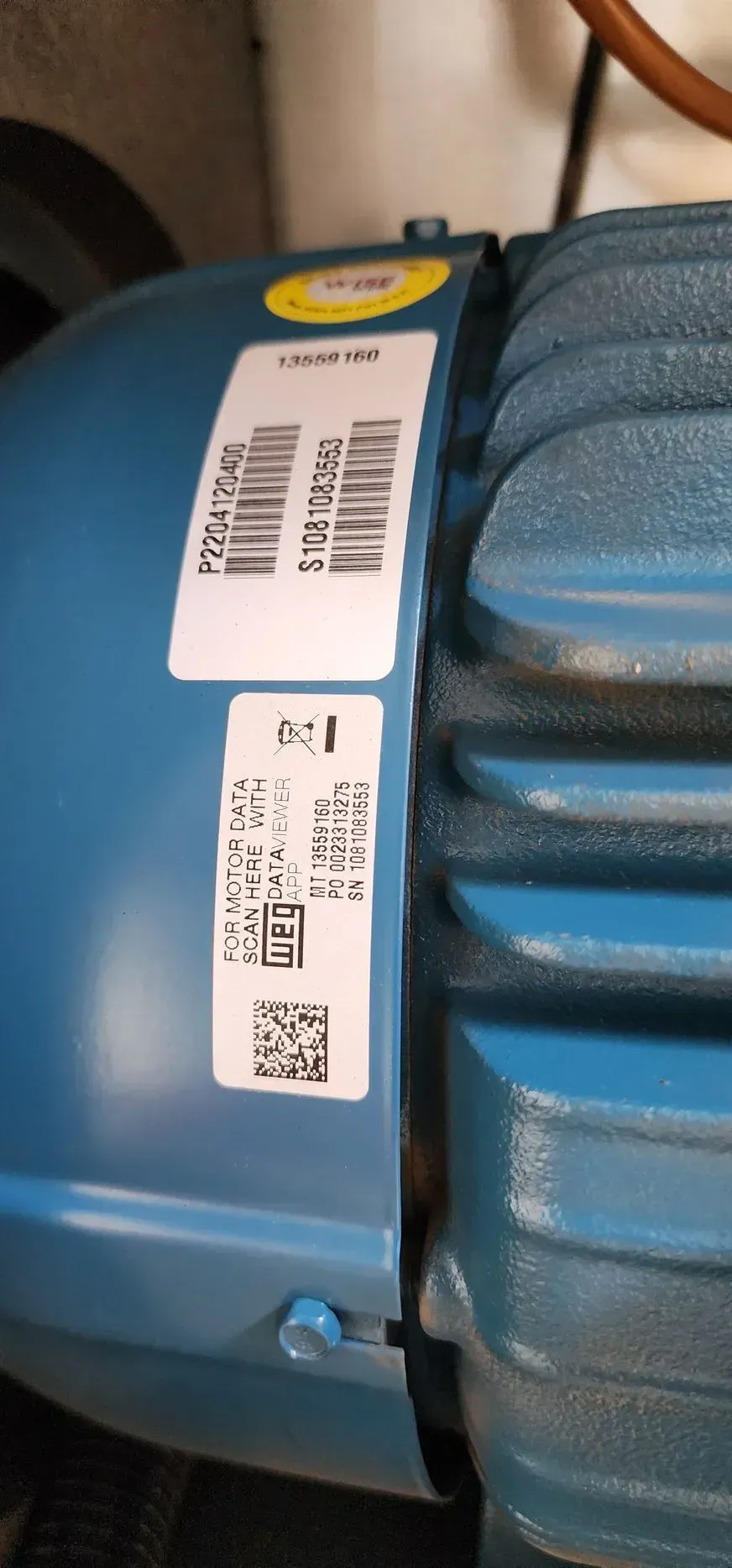 Blue motor with white labels containing text and bar codes.