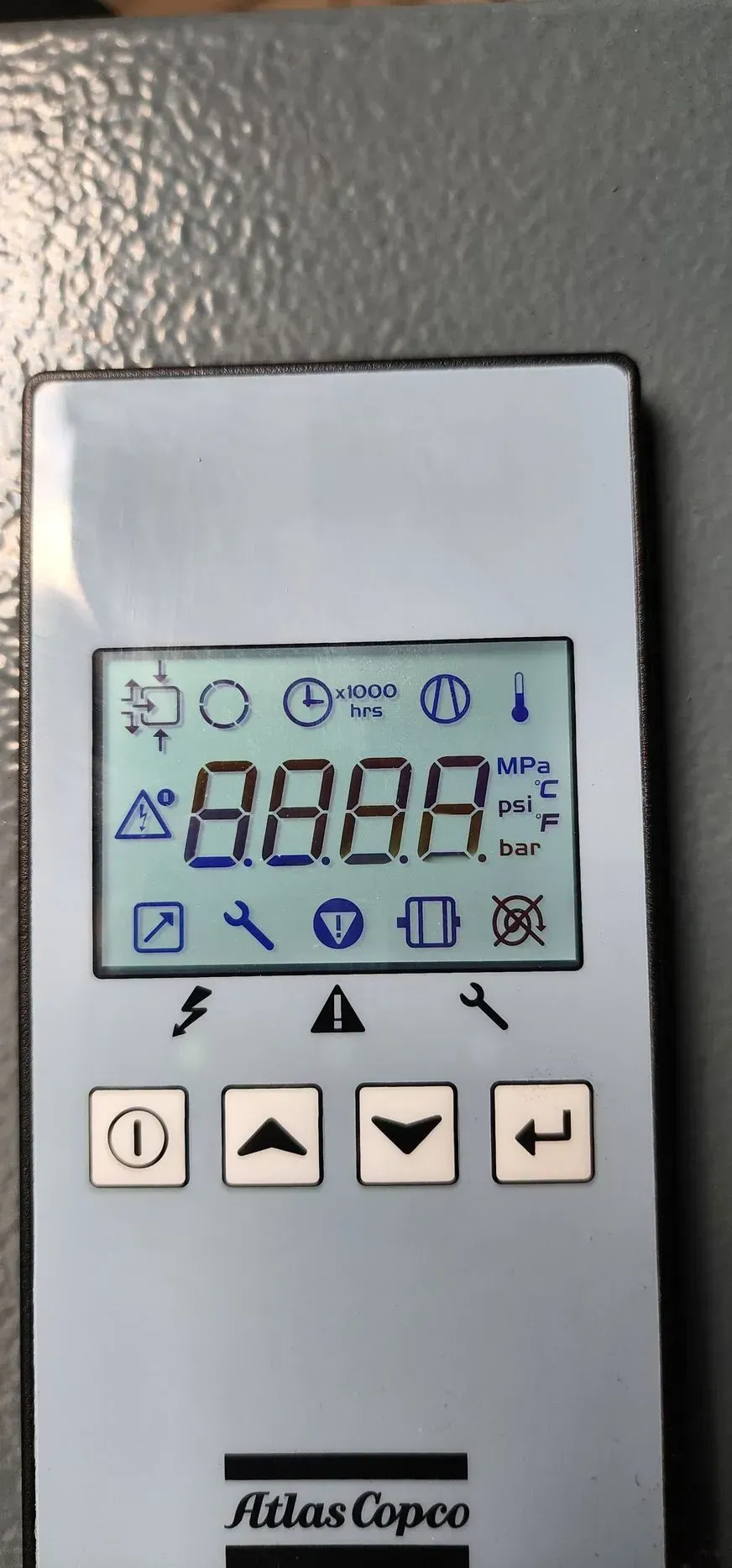 Control panel display with Atlas Copco logo, showing digital numbers and icons.