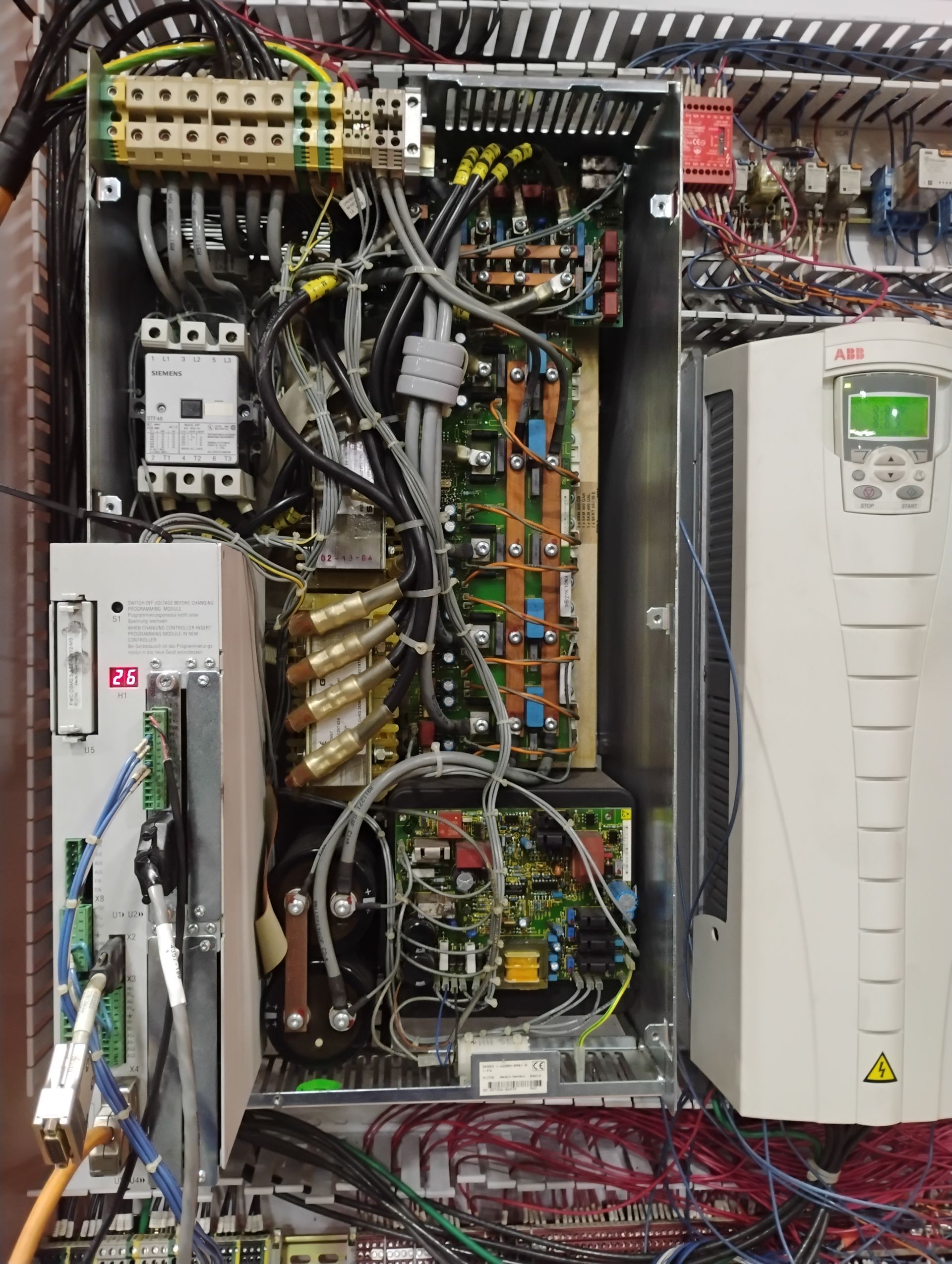 Open industrial electrical control panel with various components and wiring.