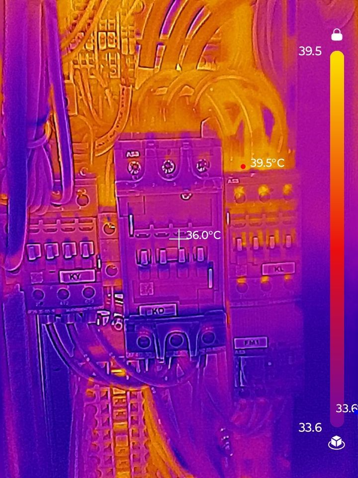 Thermal image of an electrical panel. Purple and yellow represent temperature variations. A component at 36°C is visible.