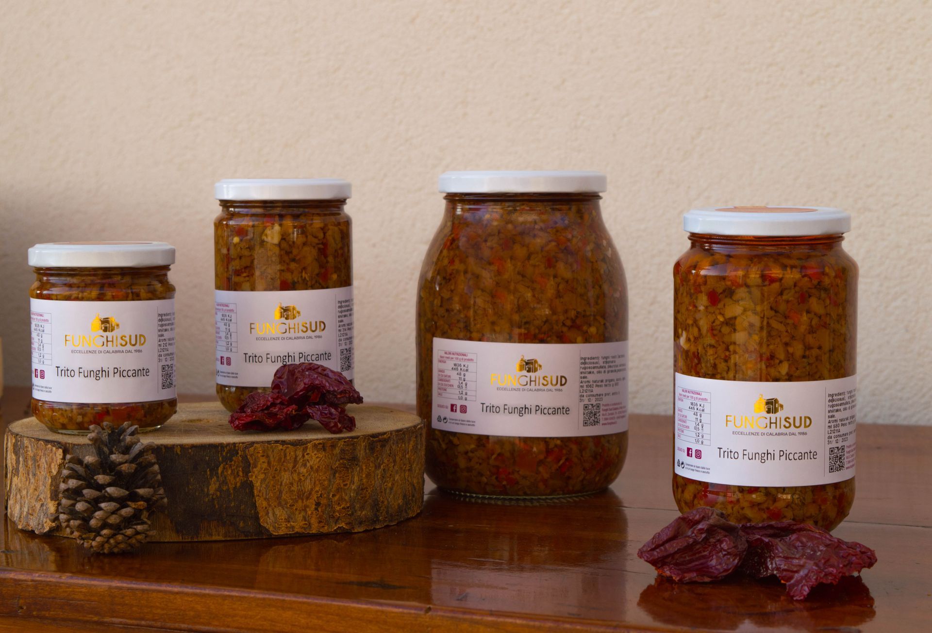 Quattro barattoli di cibo sono appoggiati su un tavolo di legno.