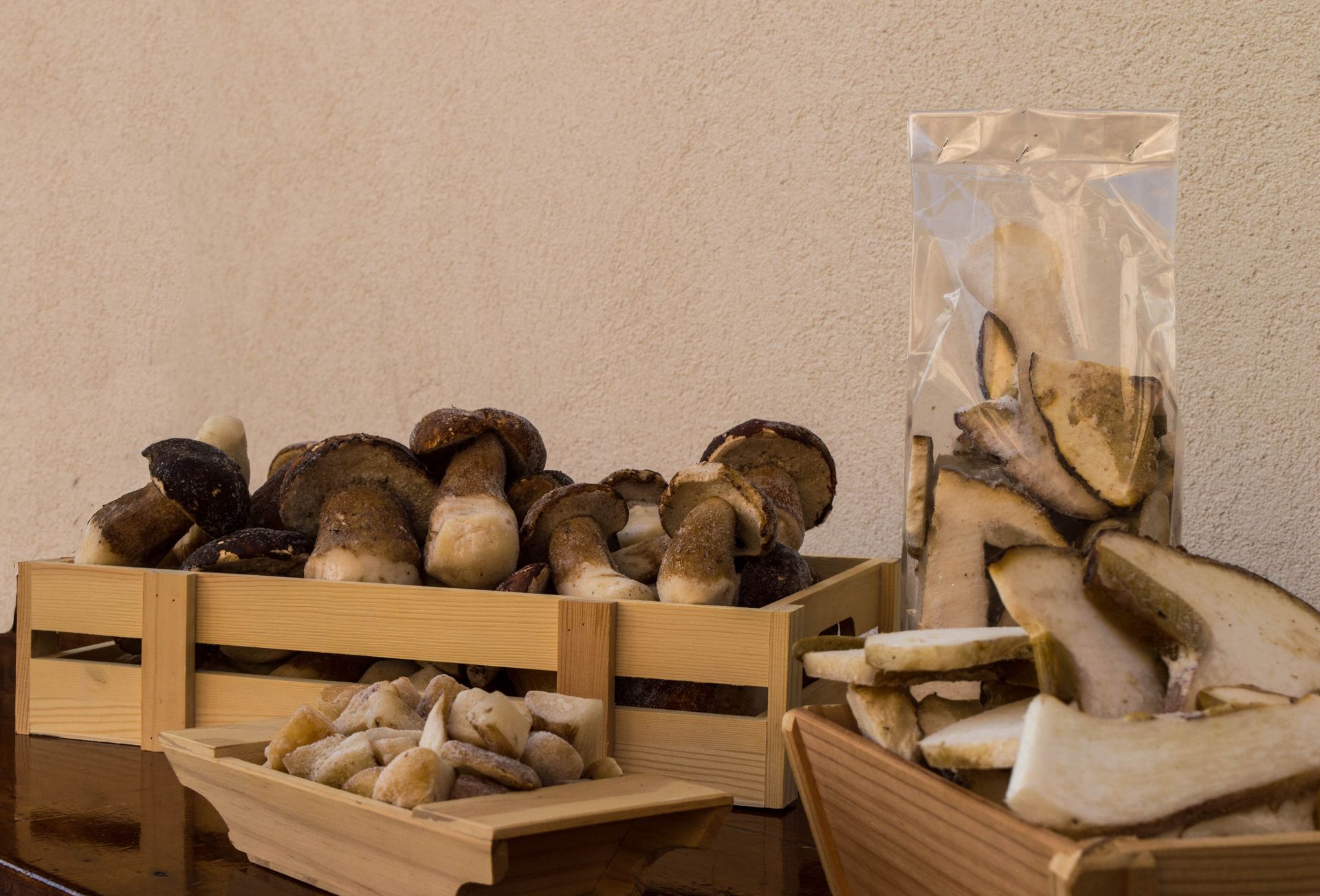 Una cassa di legno piena di funghi accanto a un sacchetto di funghi.