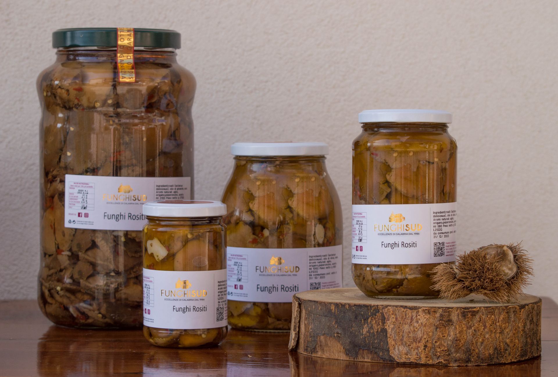 Quattro barattoli di cibo sono appoggiati su un tavolo di legno.