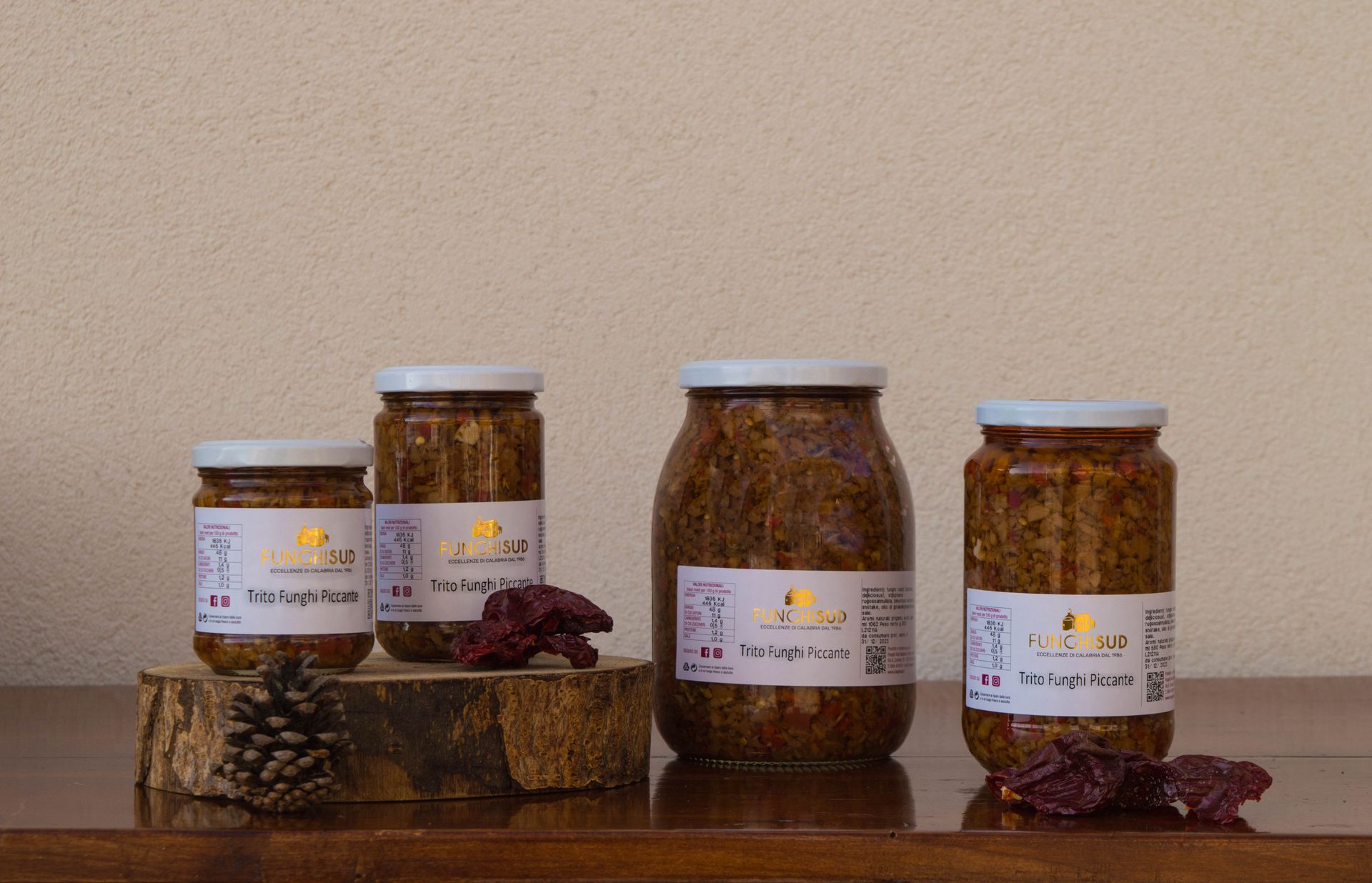 Quattro barattoli di cibo sono appoggiati su un tavolo di legno.