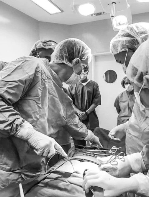 A group of surgeons are operating on a patient in an operating room.