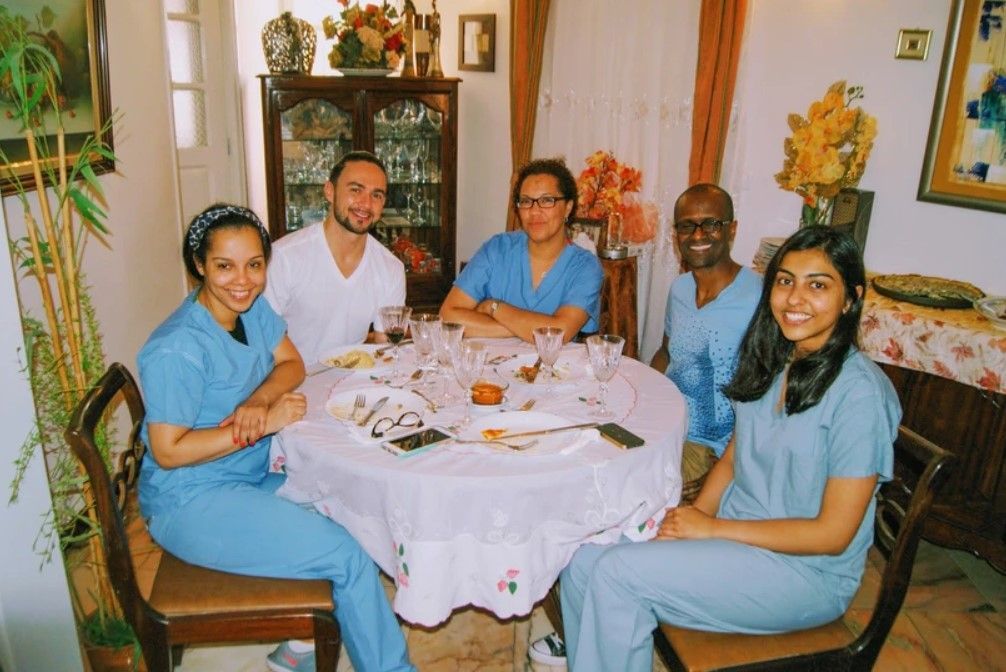 A group of people in scrubs are sitting around a table