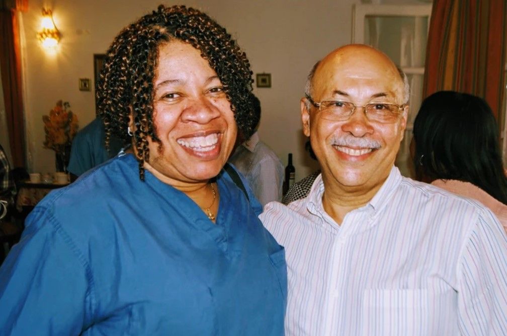 A man and a woman are posing for a picture and smiling