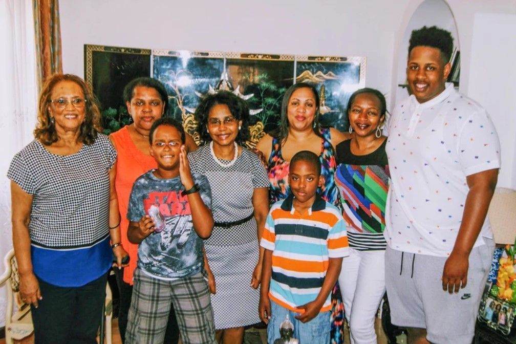 A group of people are posing for a picture together in a living room.