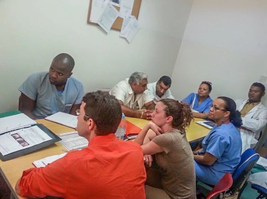 A group of people are sitting around a table having a meeting