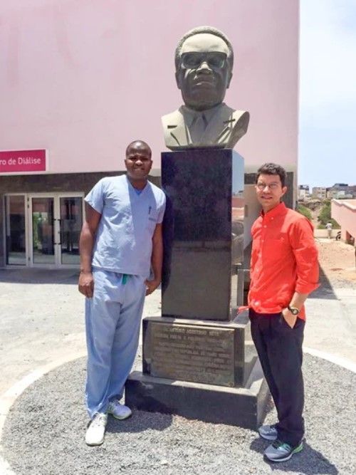 Two men standing in front of a statue of a man