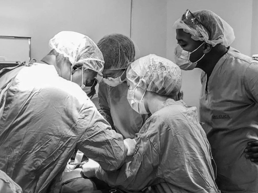 A group of surgeons are operating on a patient in an operating room.