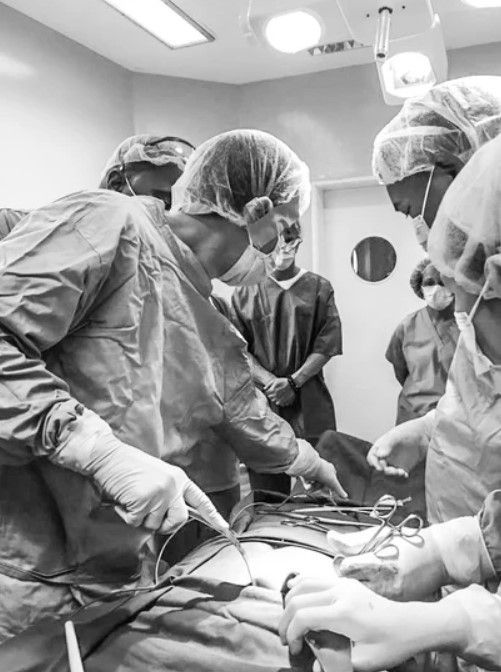 A group of surgeons are operating on a patient in an operating room.