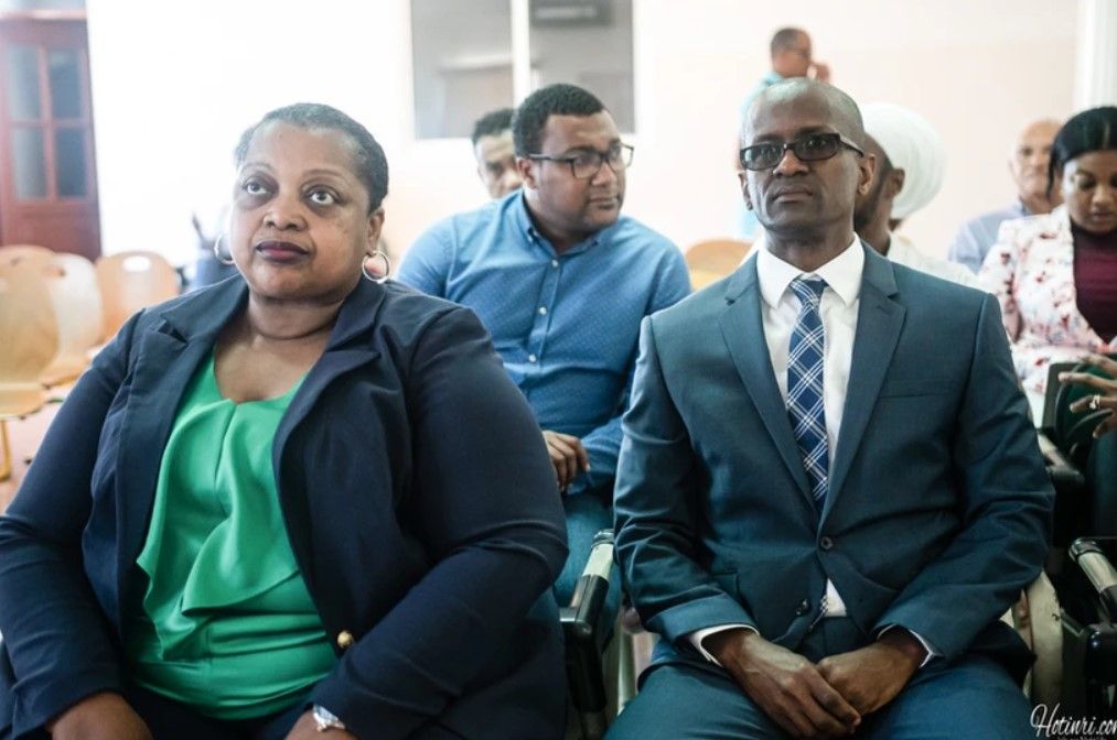 A man and a woman are sitting next to each other in a room.