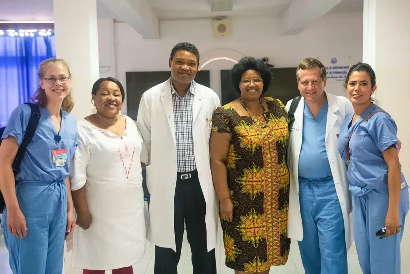A group of doctors and nurses are posing for a picture.