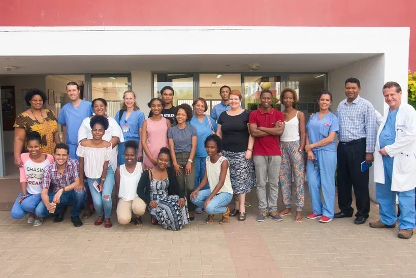 A large group of people are posing for a picture in front of a building.