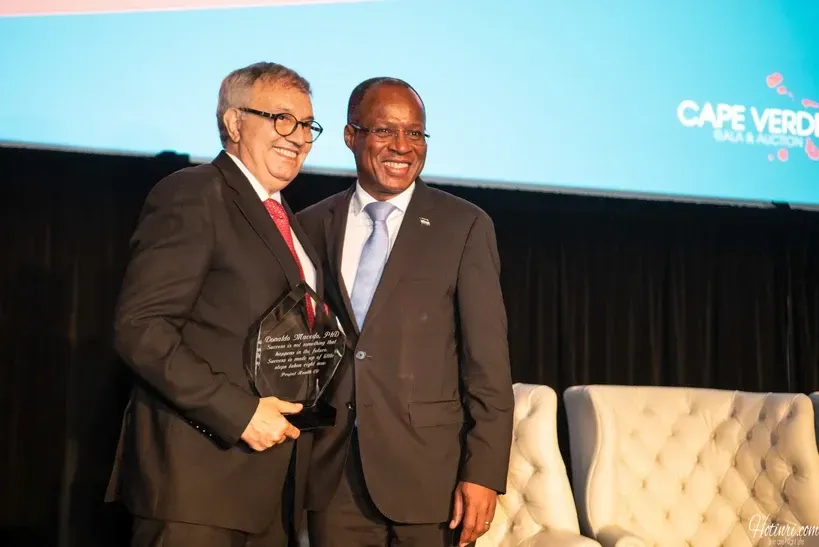 Two men in suits and ties are standing next to each other on a stage.