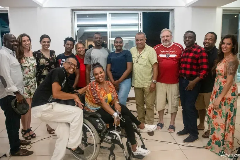A group of people are posing for a picture with a woman in a wheelchair.