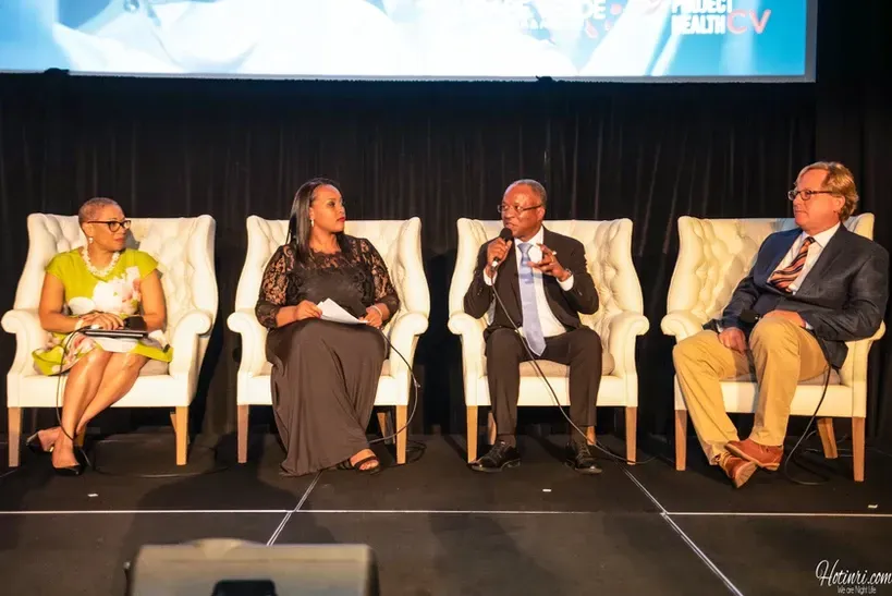 A group of people are sitting in chairs on a stage.