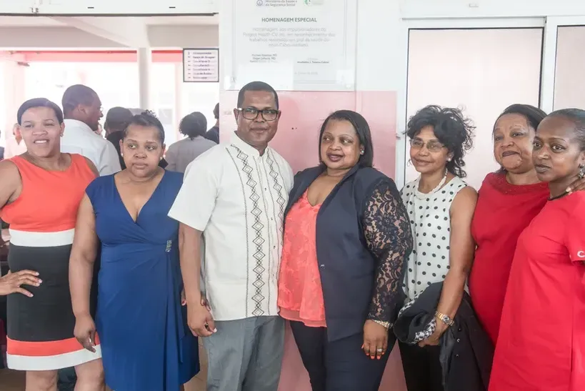 A group of people are posing for a picture together in a room.