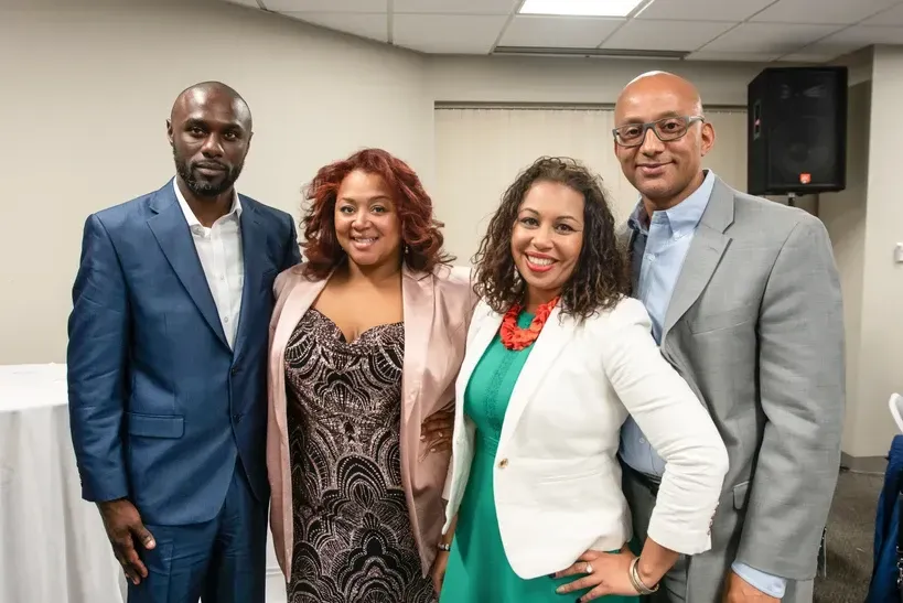 A group of people are posing for a picture together in a room.