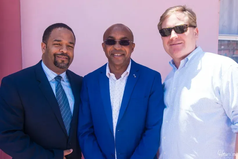Three men in suits and ties are posing for a picture.