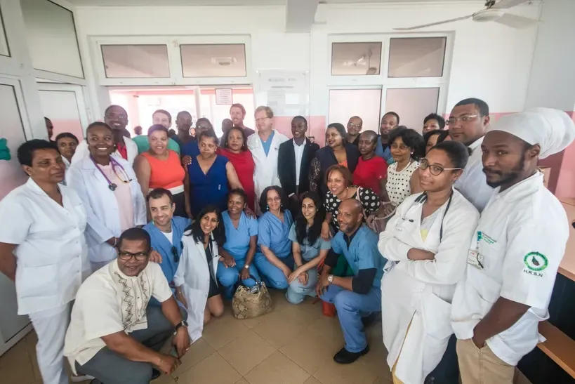 A group of people are posing for a picture in a room.