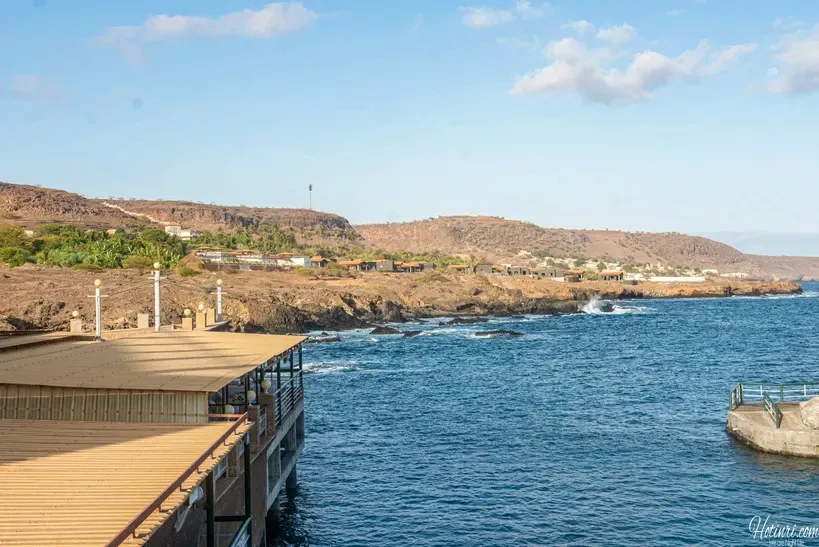 A pier overlooking a body of water with mountains in the background.