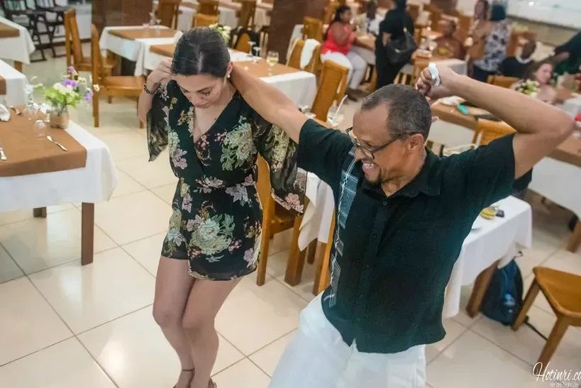 A man and a woman are dancing in a restaurant.