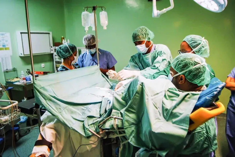 A group of surgeons are working on a patient in an operating room