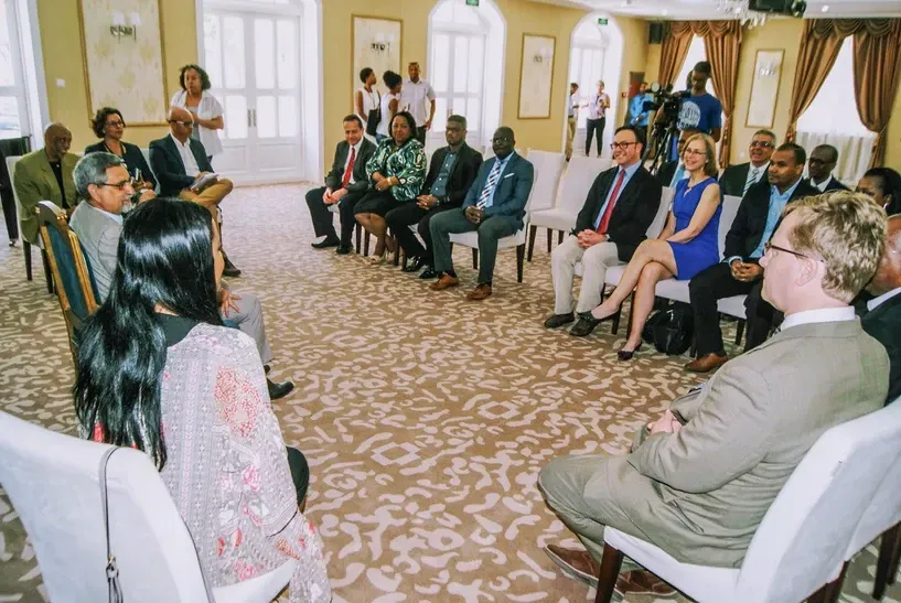 A group of people are sitting in a circle in a room
