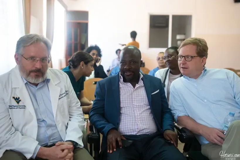 Three men are sitting next to each other in a room.