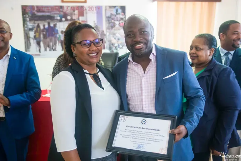 A man and a woman are posing for a picture while holding a certificate.