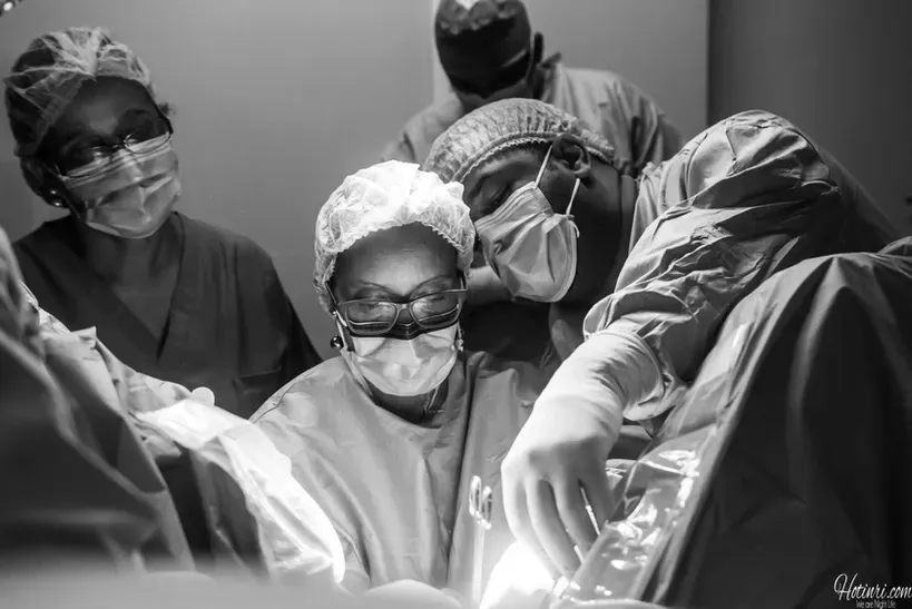 A group of surgeons are operating on a patient in an operating room.