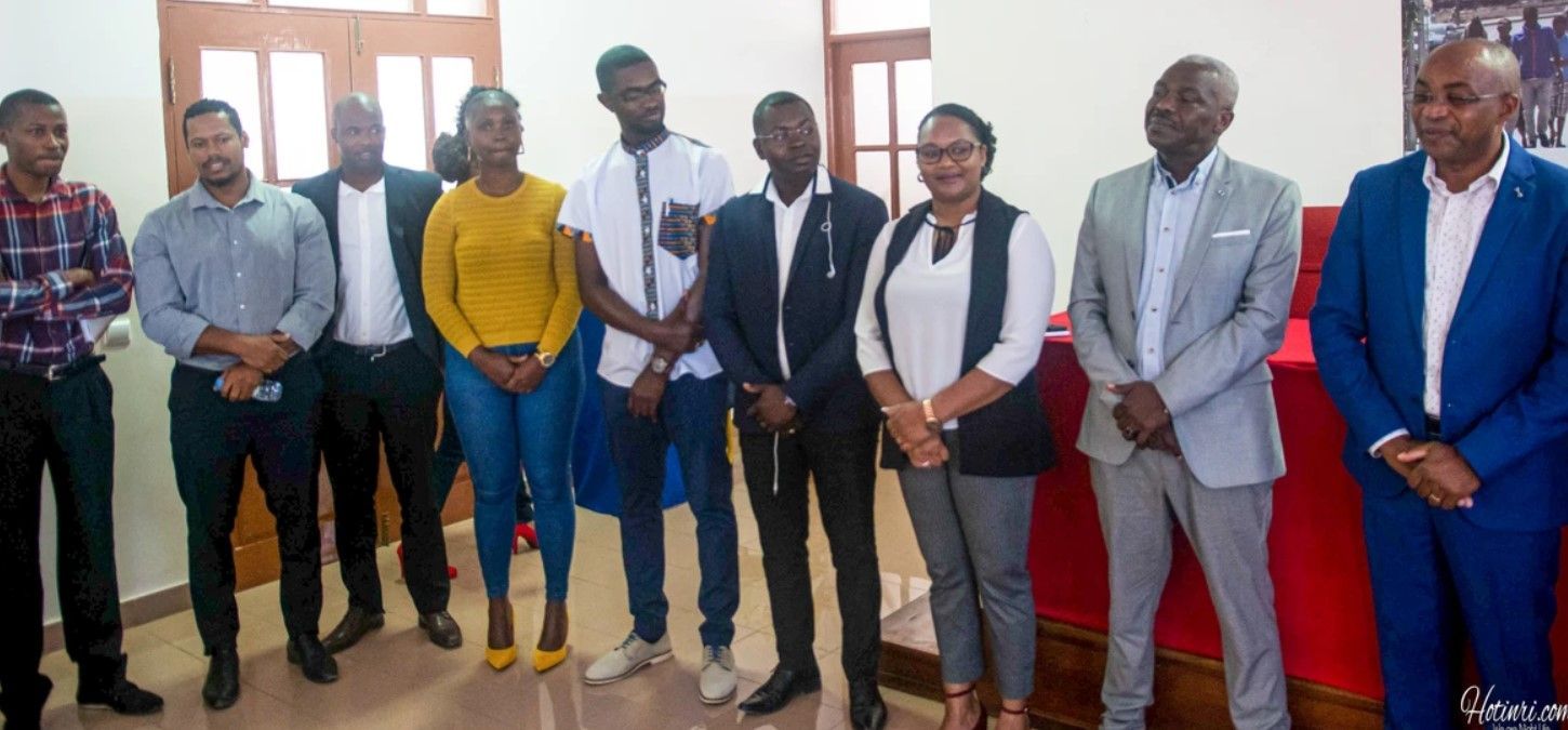 A group of people are standing next to each other in a room.