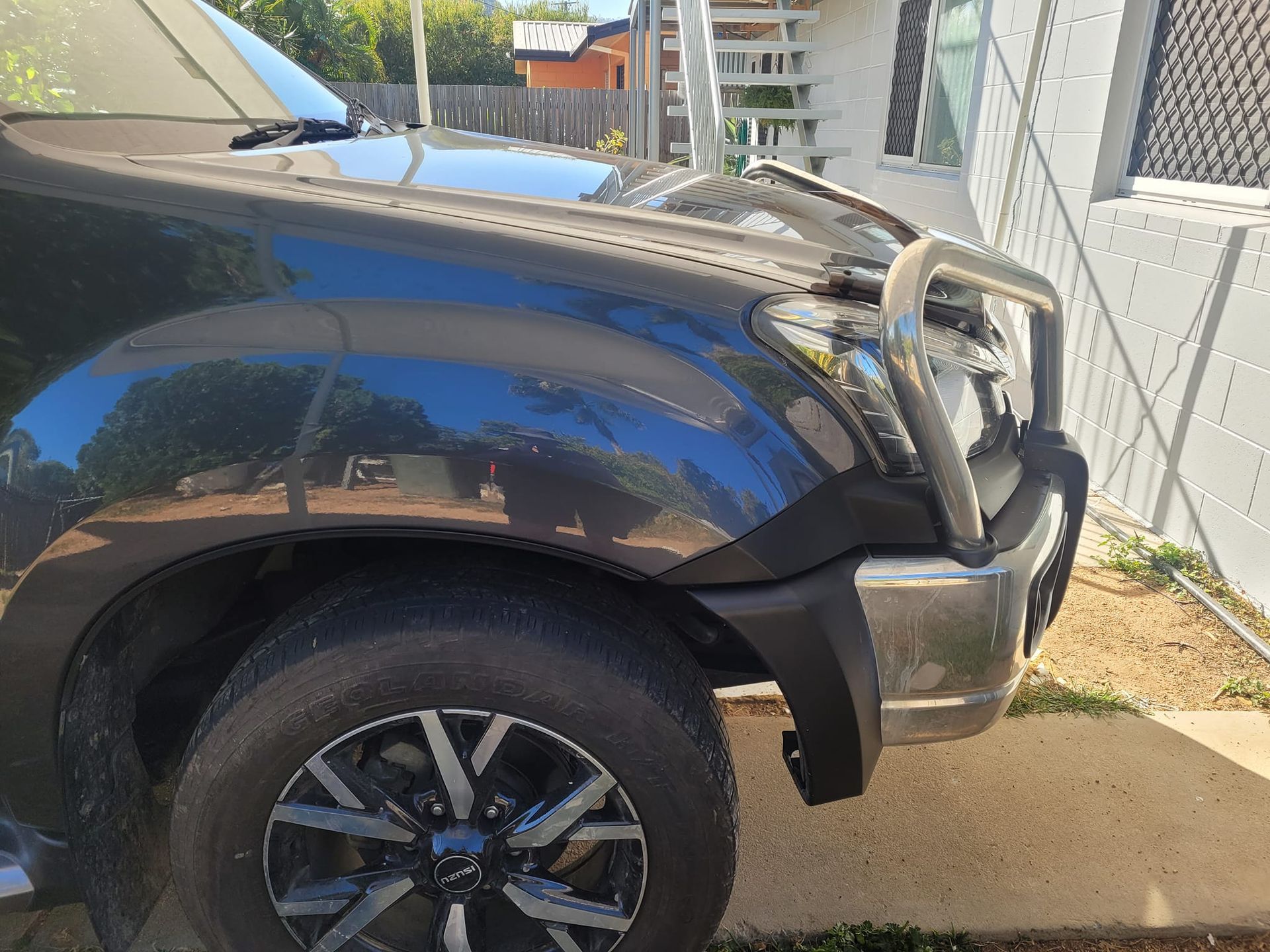 A Black Truck is Parked on the Side of the Road in Front of a House — Dek-A-Dent Townsville In Wulguru, QLD