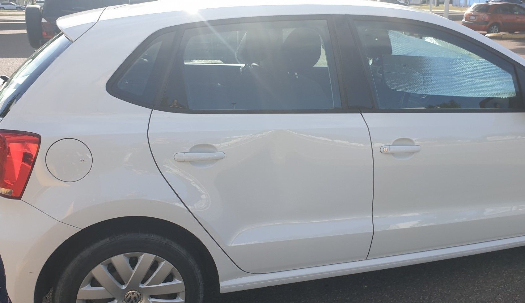A White Car is Parked on the Side of the Road — Dek-A-Dent Townsville In Wulguru, QLD