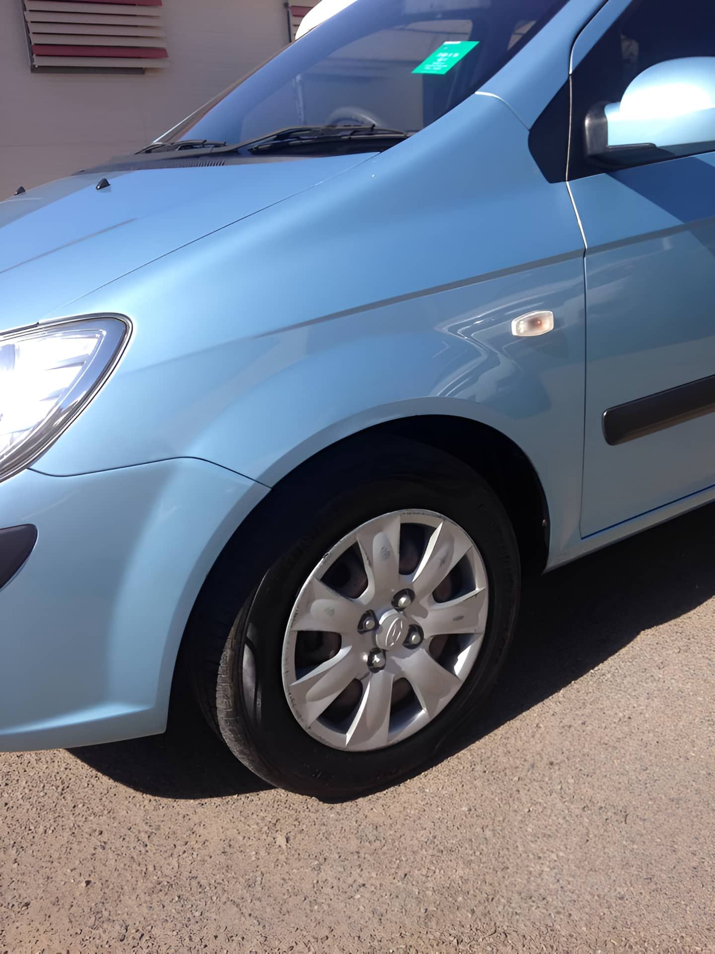 A Blue Car is Parked on the Side of the Road — Dek-A-Dent Townsville In Wulguru, QLD