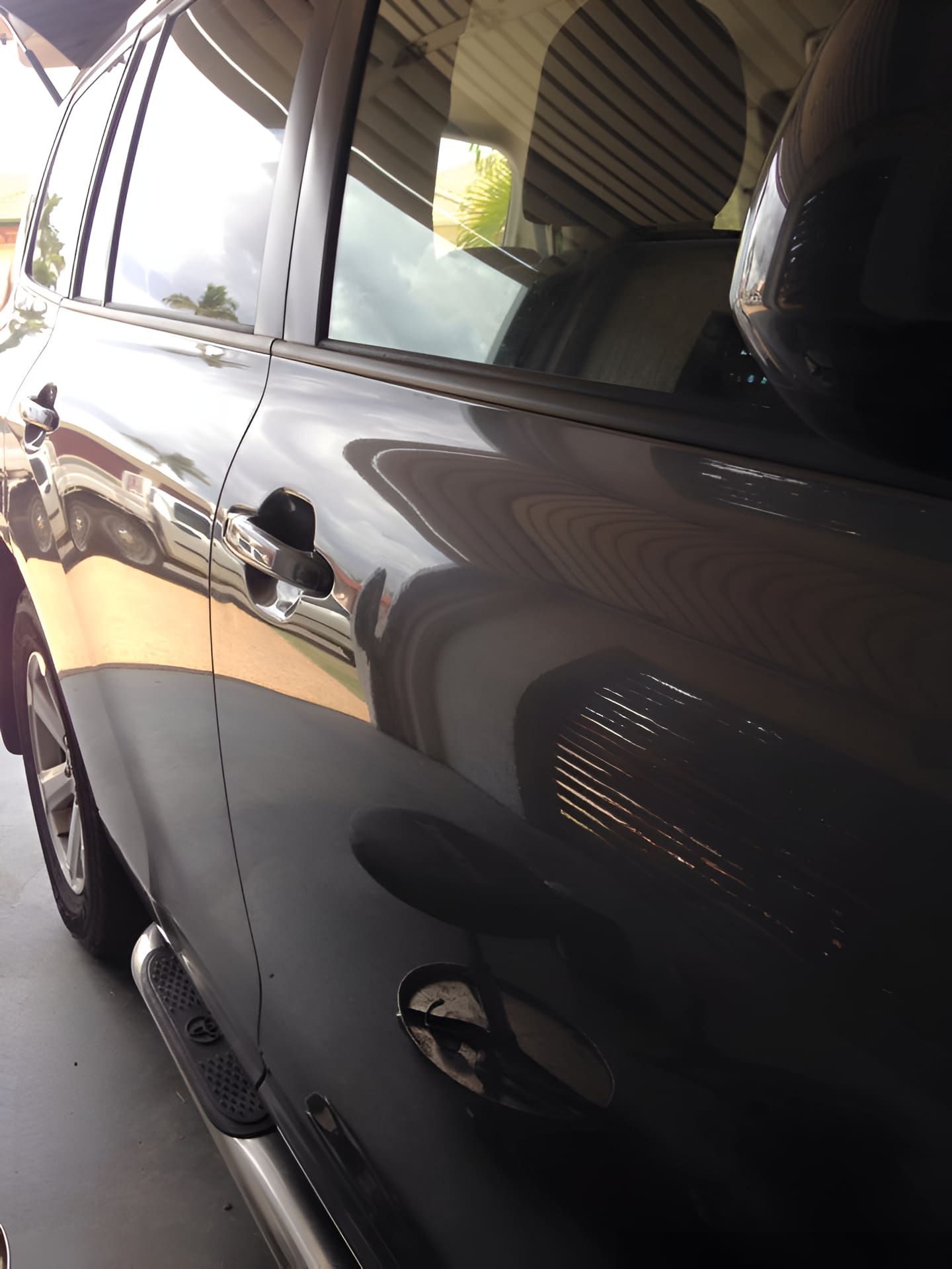 A Black Car is Parked in a Garage With the Door Open — Dek-A-Dent Townsville In Wulguru, QLD