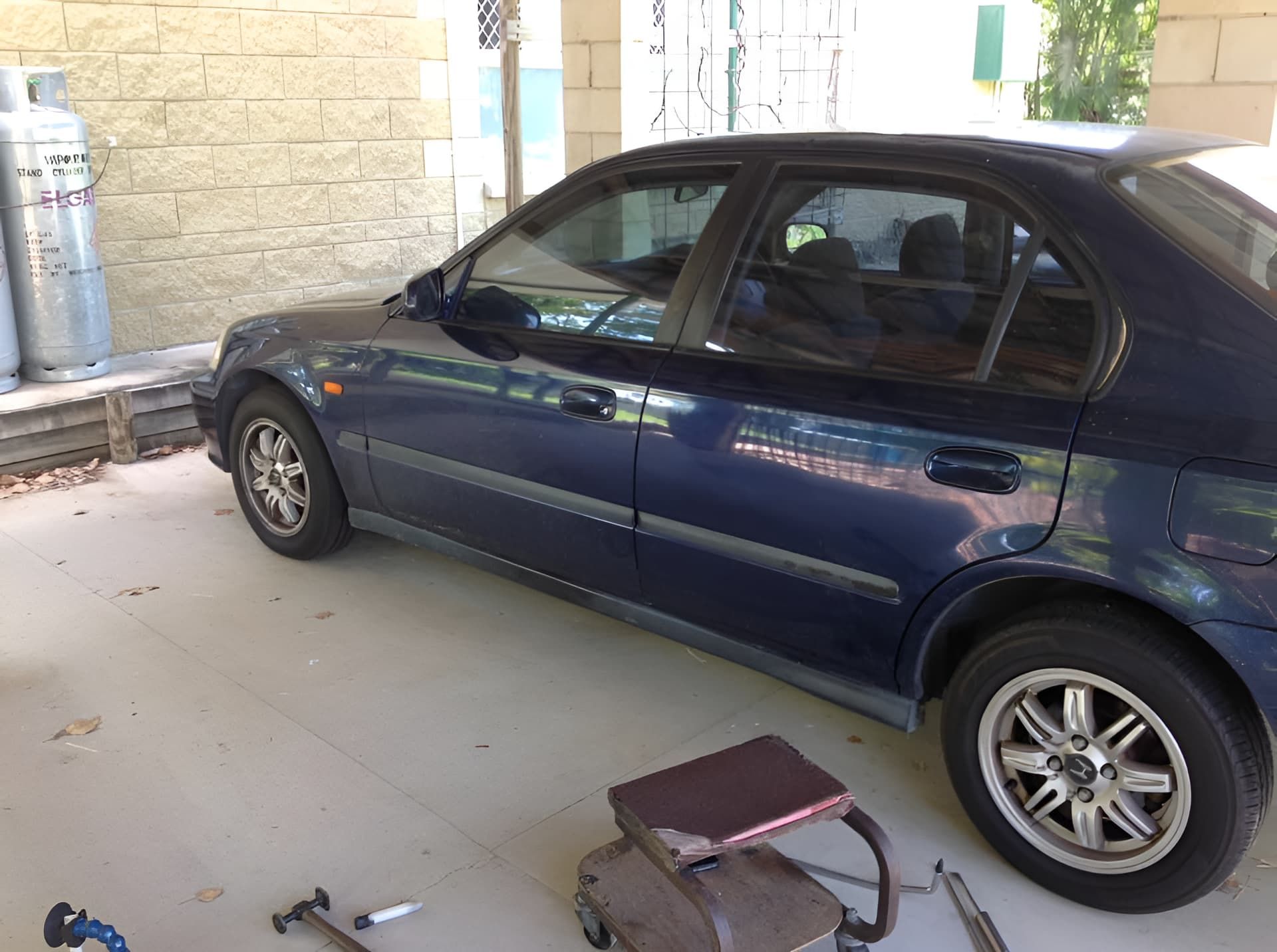 A Blue Car is Parked in a Garage Next to a Gas Tank — Dek-A-Dent Townsville In Wulguru, QLD