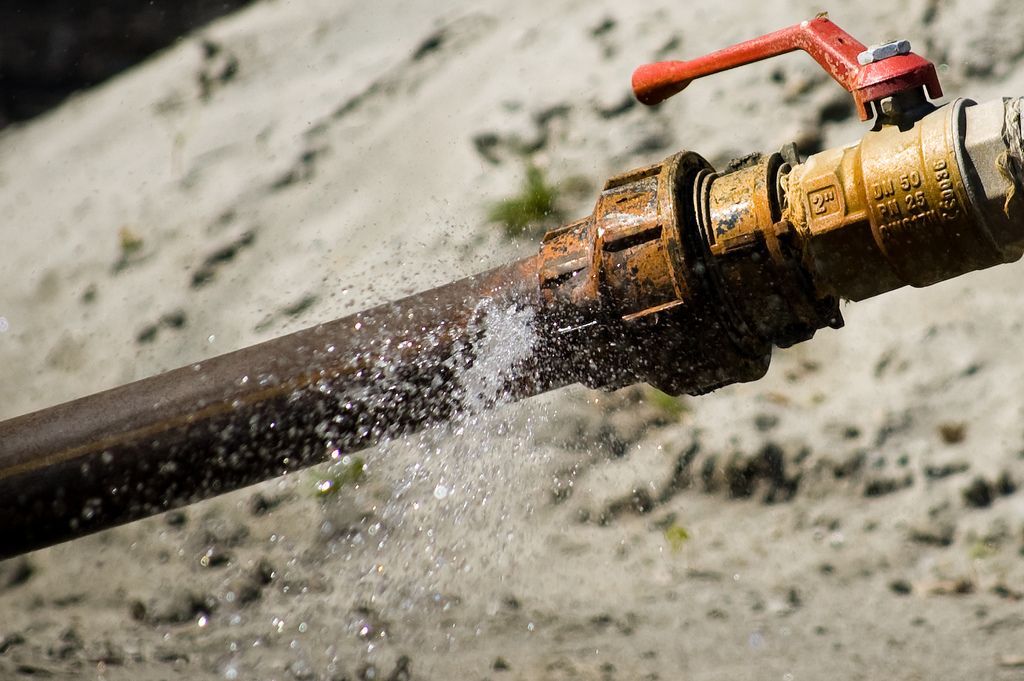 A close up of a water pipe with water coming out of it.