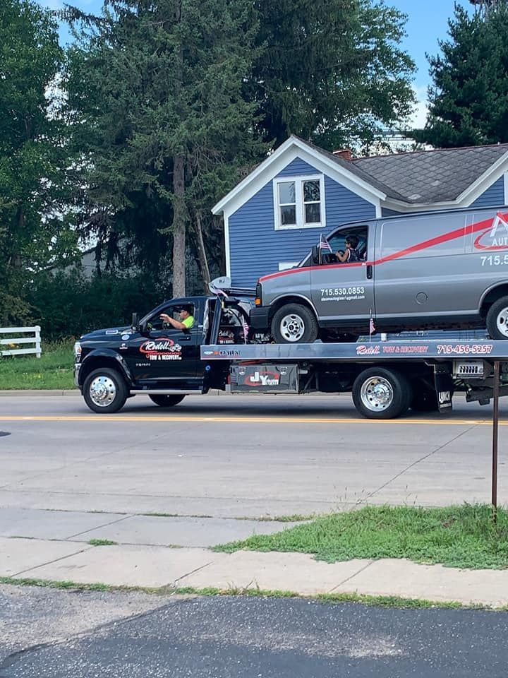 A tow truck is carrying a car on the back of it