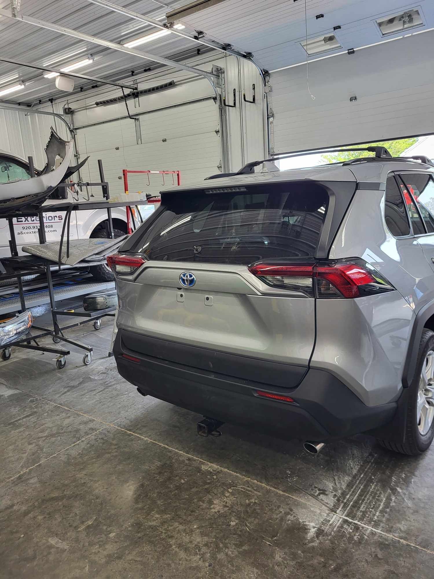 A silver toyota rav4 is parked in a garage.