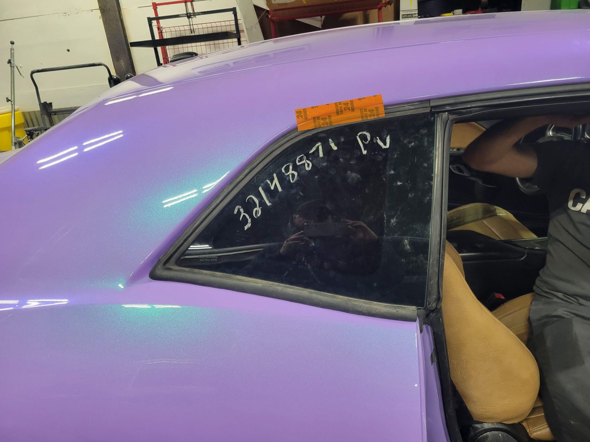 A purple car is being worked on in a garage