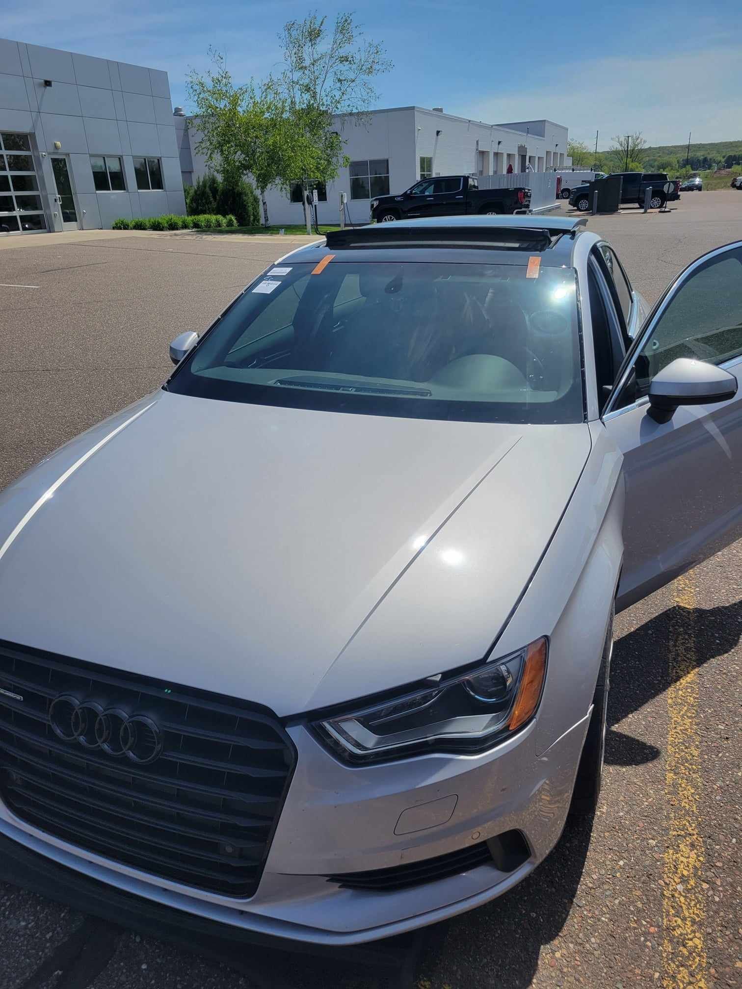A white audi a3 is parked in a parking lot.