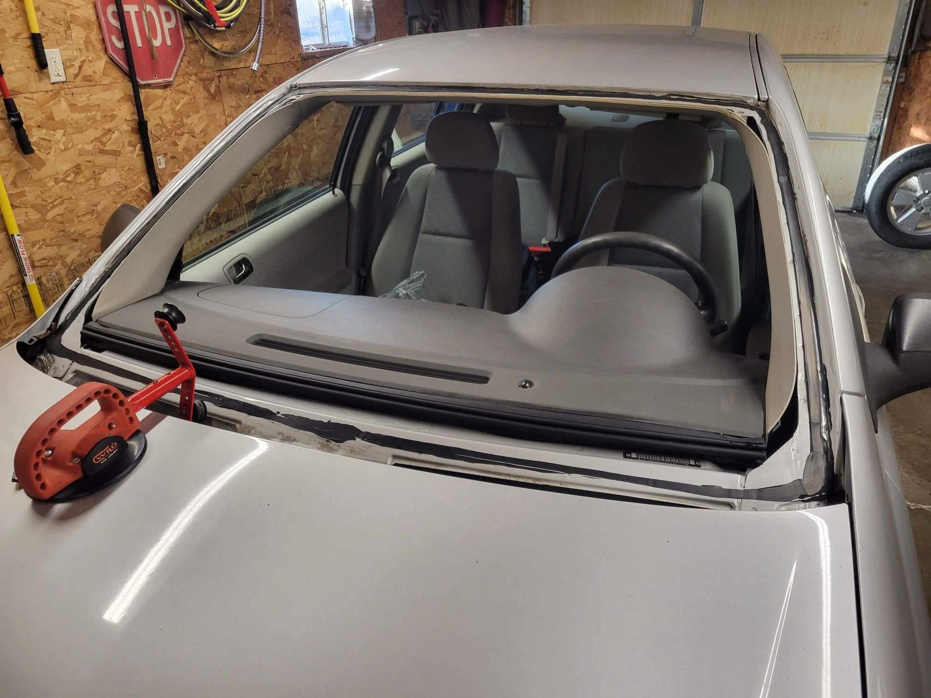 A car with a broken windshield is sitting in a garage.