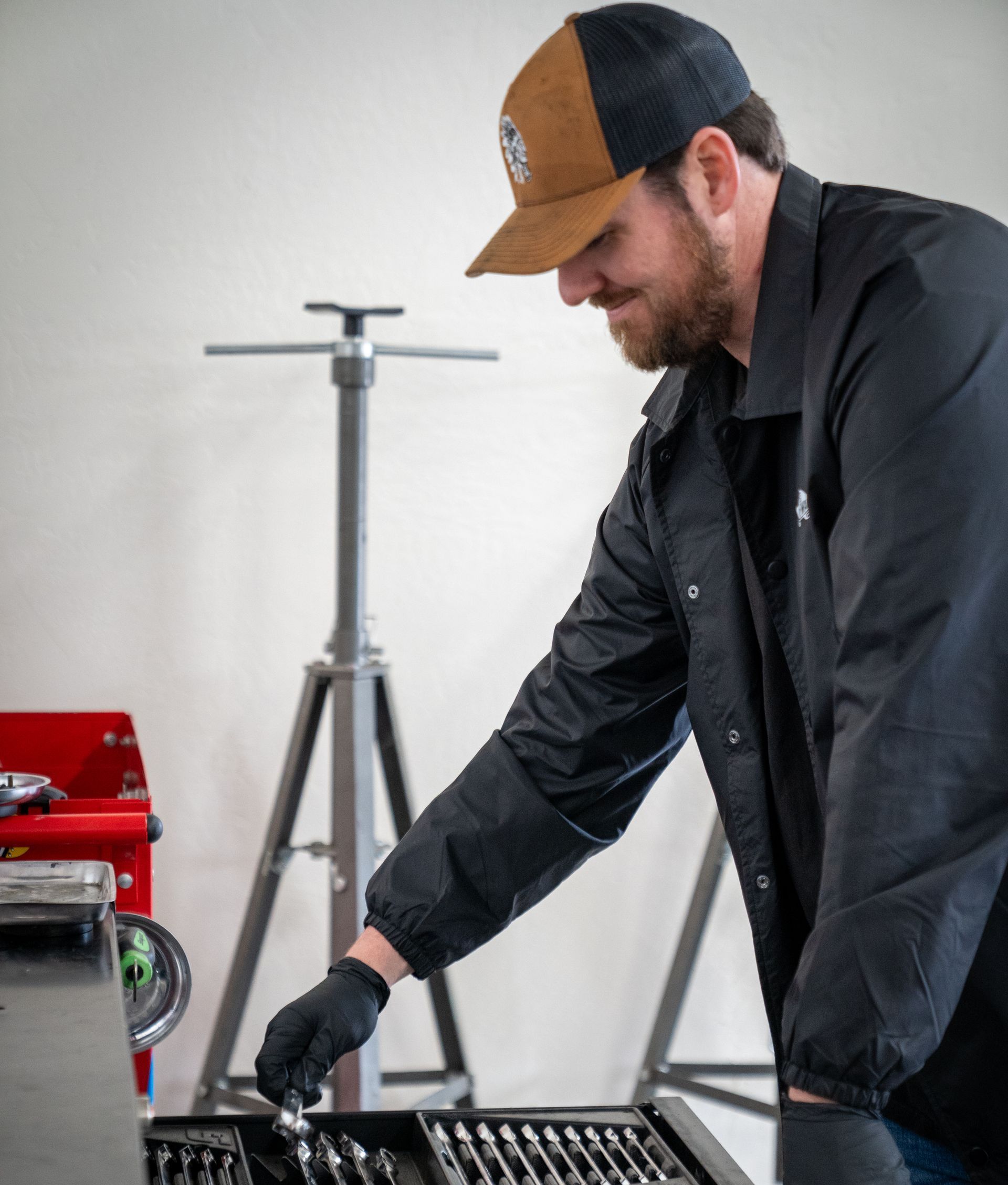A man wearing a hat is working on a toolbox