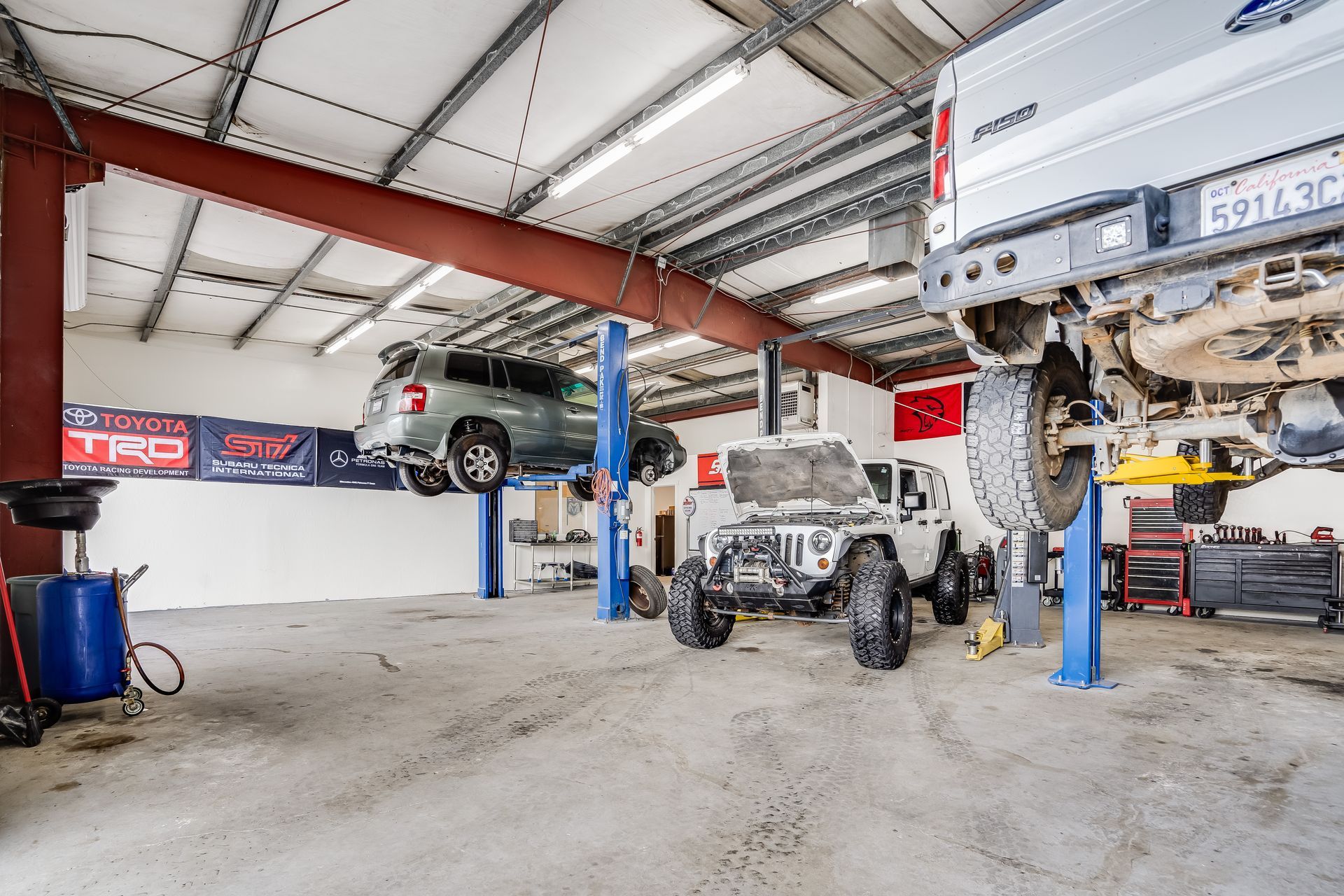 A jeep is sitting on a lift in a garage.