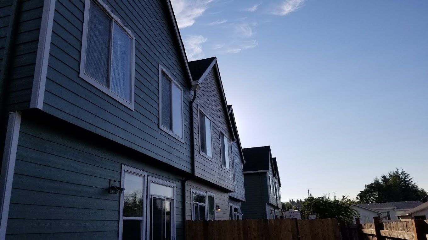 A row of houses with a blue sky in the background.